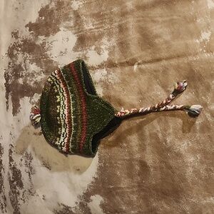 Winter beanie hat has ear covers with braids and pom pom. Size: OS